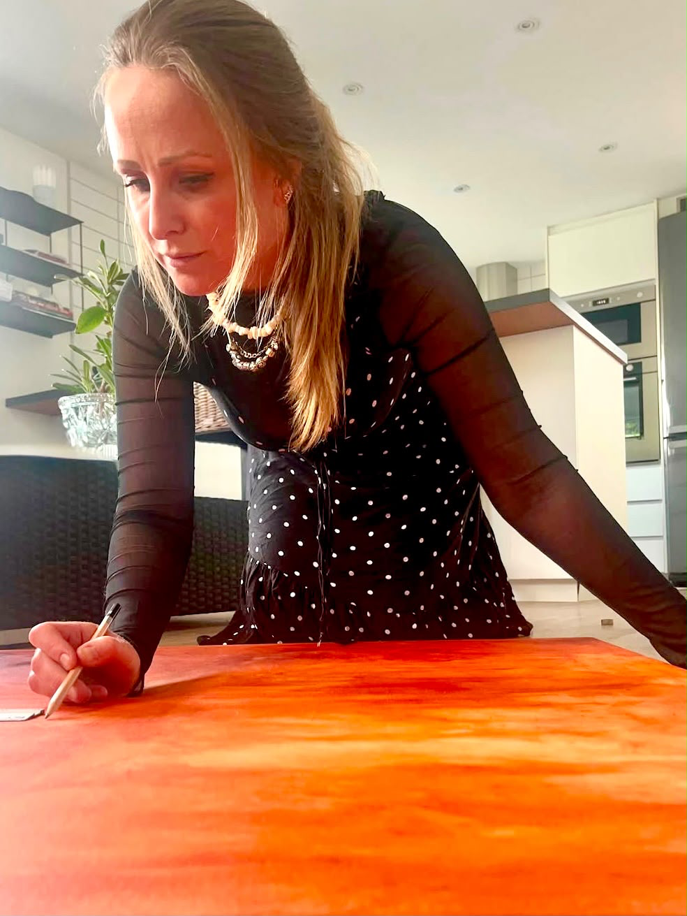 Jessica målar en stor orange canvas